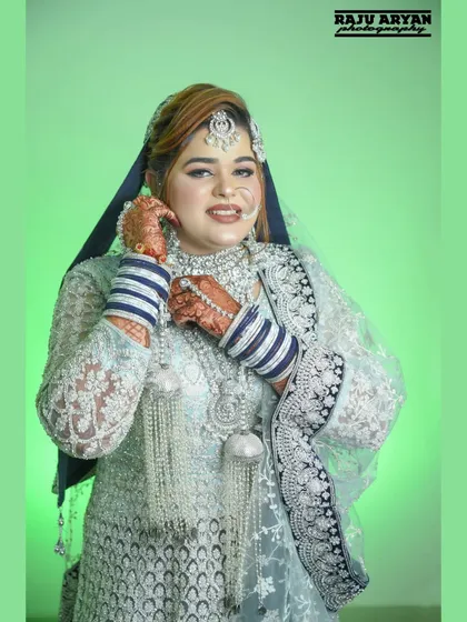 A lovely candid moment as the bride adjusts her earring. This pose looks natural and highlights the beautiful jewelry and her joyful expression.