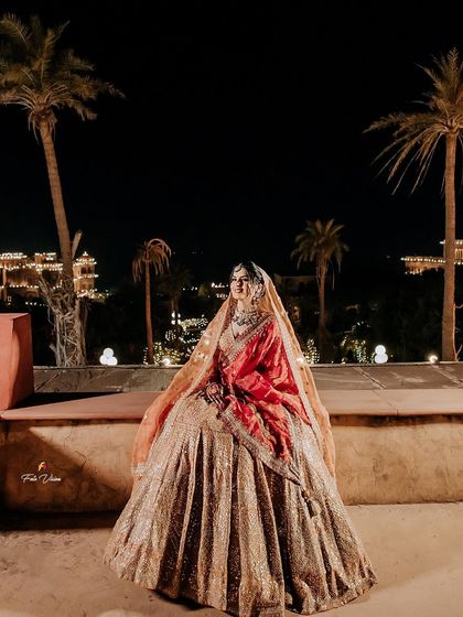 A breathtaking night portrait of the bride with the illuminated palace in the background. This shot combines bridal beauty with the magical ambiance of a royal wedding venue.