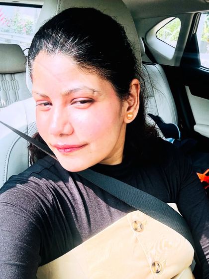 A car selfie showing the top half of my outfit. The simple black long-sleeve top provides a perfect base for the statement high-waisted skirt, creating a balanced and chic look.