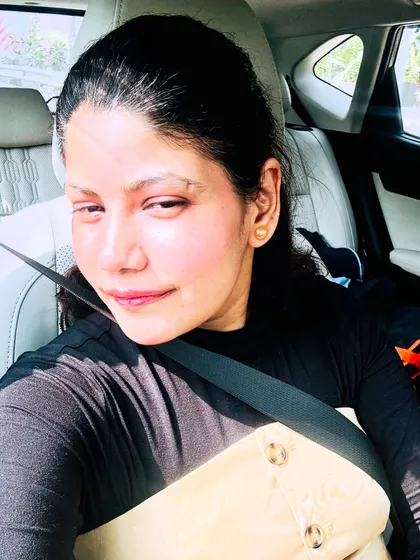 A car selfie showing a layered beige and black top, highlighting a casual but put-together look.