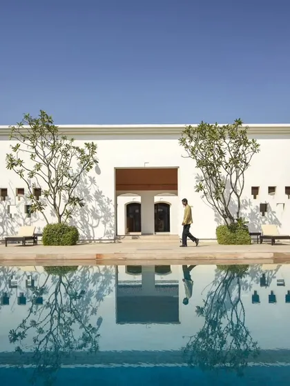 The serene poolside of our hotel project in Bodhgaya, designed as a tranquil sanctuary that encourages reflection. The architecture harmonizes with the water, creating a seamless experience of peace.
