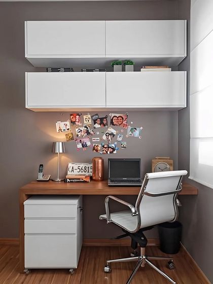 A clean and simple home office corner. The design features a wooden desk, a mobile drawer unit for flexibility, and white overhead cabinets for ample, concealed storage.