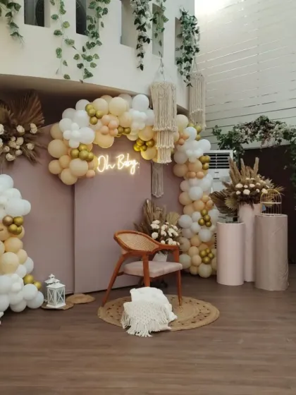 A chic and modern boho baby shower. This 'Oh Baby' setup features a neutral color palette, macrame hangers, pampas grass, and a stylish neon sign.