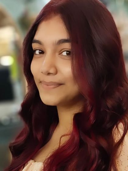 A close-up portrait showcasing the rich tones of her new red hair colour. The soft waves add a touch of glamour.