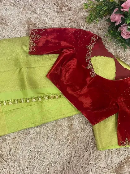 A classic combination of a red velvet hand-embroidered blouse paired with a lime green silk saree. The richness of the velvet adds a luxurious feel to the festive look.