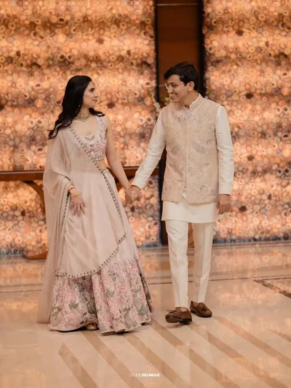 The couple walking hand-in-hand, perfectly framed by the elegant architecture of the venue.