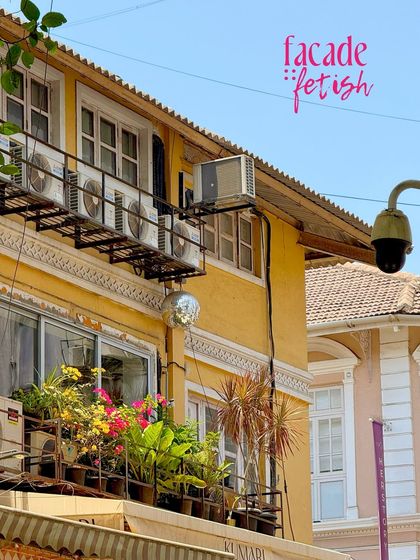 A facade fetish moment in Kala Ghoda, with a disco ball hanging incongruously next to rows of air conditioners on a yellow building.