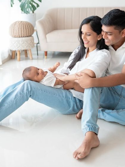A family of three relaxing on the floor together.