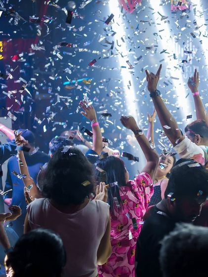 The crowd with hands up during a confetti moment.