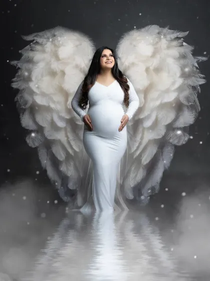 An angelic celebration of new life. This creative portrait combines a classic white maternity gown with our beautiful angel wings prop for a truly magical effect.