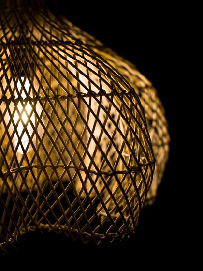A close-up of the lit globe lamp, focusing on how the light filters through the dense weave. This creates a soft, moody light that is perfect for creating a relaxing atmosphere.