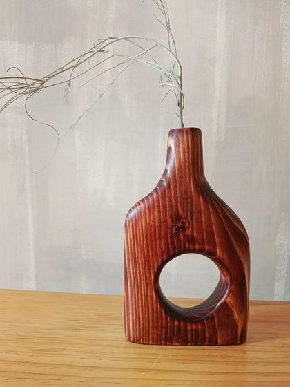 A duplicate of 154, our hand-carved wooden vase, styled with a single dried stem. Its minimalist and organic shape brings a sense of calm and nature indoors.