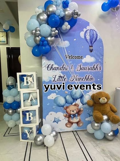 A 'Welcome Little Munchkin' setup for a baby boy. This includes a personalized backdrop, 'BABY' blocks, and a blue, white, and silver balloon arrangement.