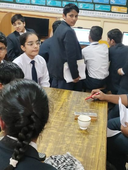 An instructor engages with a group of curious students, explaining a complex concept in a simple and accessible way.