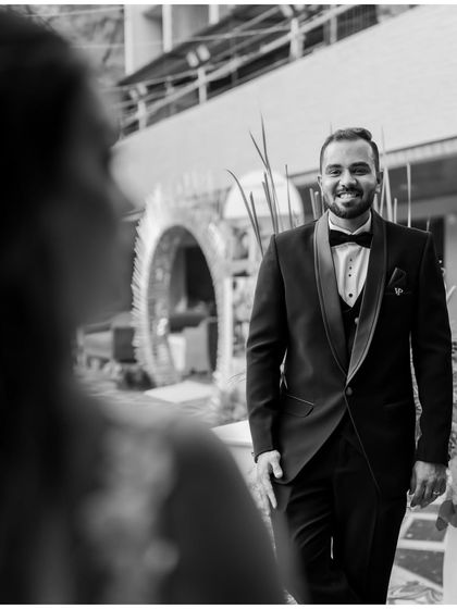 A classic black and white shot of the groom's first look. His smile says it all.