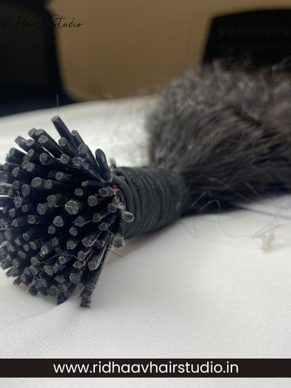 A macro shot of the tips on our raw curly I-Tip extensions, showing the craftsmanship that goes into each strand.