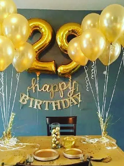 An elegant 29th birthday setup featuring large gold number balloons and matching balloon bouquets. This simple arrangement is perfect for a dinner party or a focused celebration area.