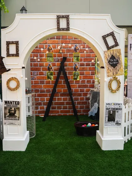 An enchanting photo booth area with a brick backdrop, "Wanted" posters, and other props from the wizarding world.