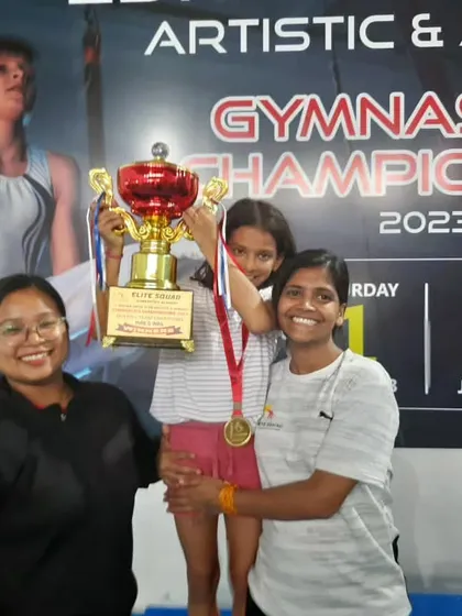 A proud student holding her championship trophy high. Moments like these are what make all the hard work worthwhile.