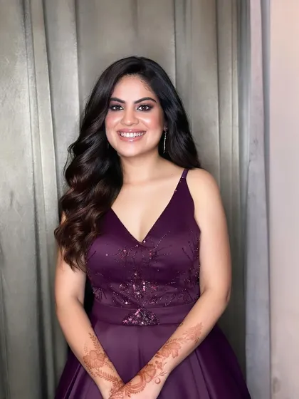 A smiling client showing off her natural waves hairstyle.