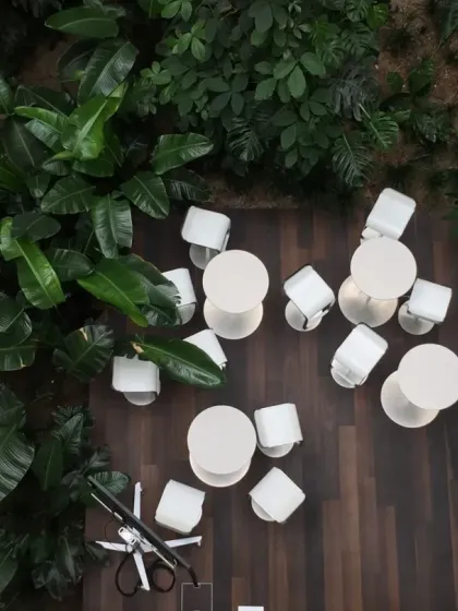 An overhead view of the social seating area within the Virchow 16 atrium. This perspective reveals how the space is carved out of the dense foliage, creating an intimate gathering spot that feels like a forest clearing.