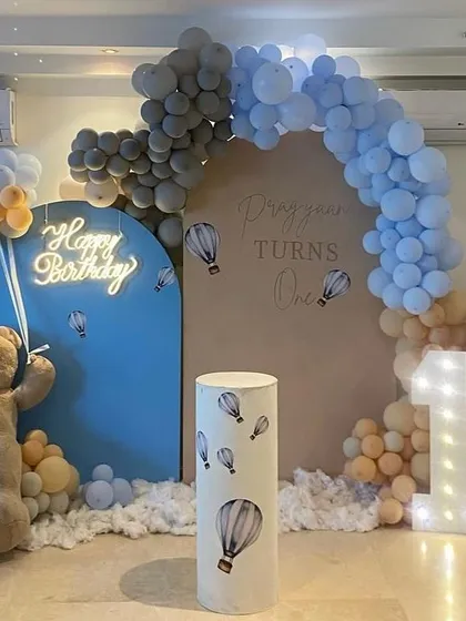 Another view of the stylish hot air balloon theme, showing the large teddy bear prop and the cloud-like effect of balloons at the base of the backdrop.