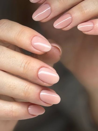 A beautiful, sheer nude pink manicure on oval-shaped nails. This is the perfect choice for an elegant, understated, and natural look.
