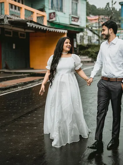A happy, candid shot of a couple walking down a wet street in Darjeeling. This image captures a real, joyful moment, showing that love shines even on a rainy day.