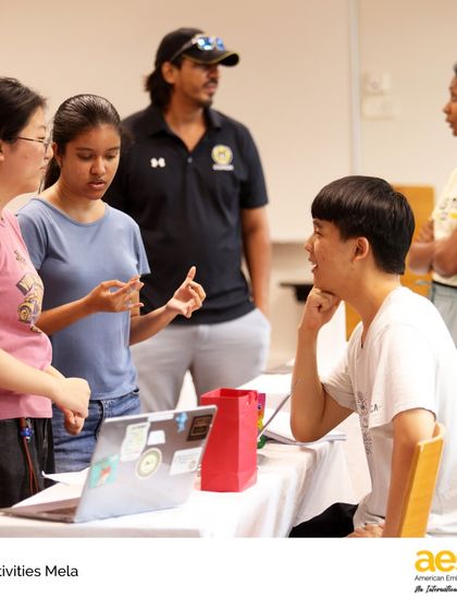 Students engage in a thoughtful conversation at a club sign-up table during the Activities Mela. This event is a key part of how we help every student find their niche and connect with peers who share their interests.