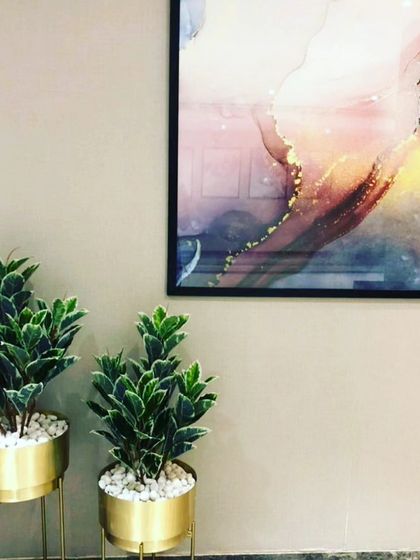 A pair of artificial variegated plants in modern gold planters. These are perfect for adding a stylish touch to a hallway or entryway.