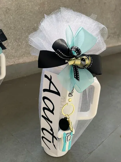 A personalized mug for "Aarti," featuring a football-themed keychain. We can customize these favors to match any party theme, from sports to superheroes.