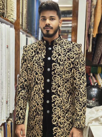 A client looking sharp in a black and gold embroidered open sherwani. The velvet inner jacket adds a layer of luxury to the overall look.