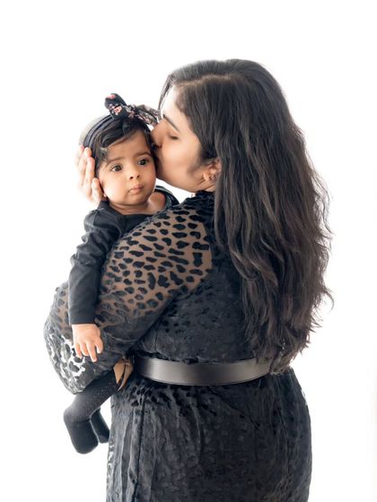 A mother gives her daughter a gentle kiss on the forehead. A timeless expression of a mother's love.