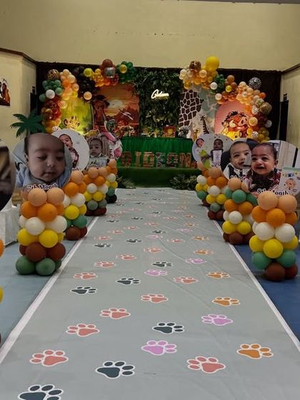 We designed a special walkway for this safari-themed party. The aisle is lined with balloon pillars topped with photos of the birthday boy's first year, leading guests to the main event area.