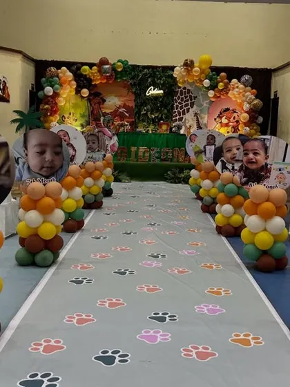 We can decorate the entire venue to match the theme. This aisle for a Lion King party is lined with balloon pillars topped with photos of the birthday boy, leading guests to the main stage.