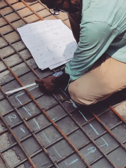 An engineer marking the rebar grid according to the structural drawings before a concrete pour. This is a critical quality control step, ensuring the steel reinforcement is correctly placed for maximum strength. We do this for every slab.