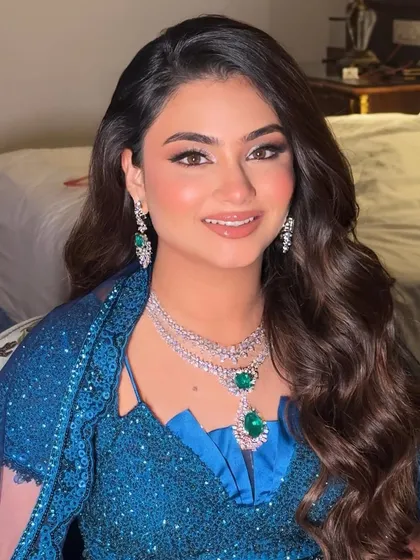 A close-up of the sangeet glam. The emerald jewelry is the perfect accent to the blue outfit and the shimmering, defined eye makeup.