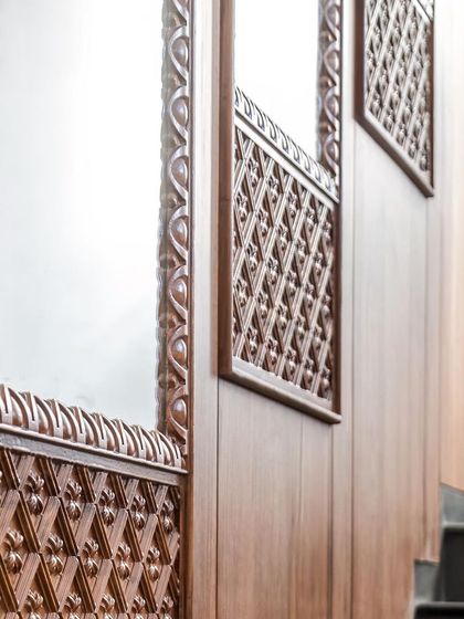 The staircase wall is a feature in itself, with teak paneling, embedded mirrors, and intricate wood-carved trims that exude regal splendor.
