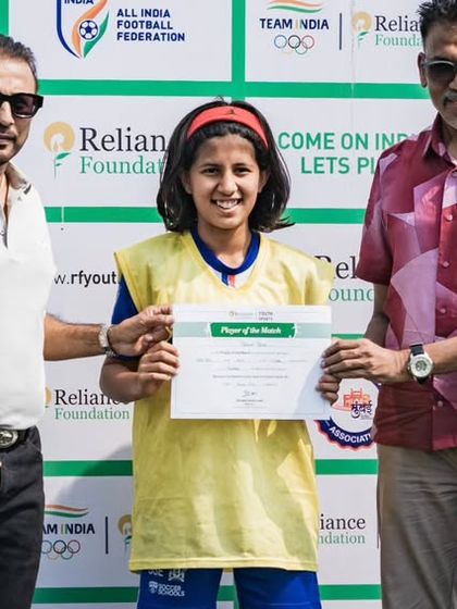 A player from our U15 girls team receives the 'Player of the Match' award at the Reliance Foundation Young Champs Football Cup. Individual excellence contributing to team success.