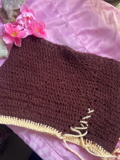 A top-down shot focusing on the handmade quality of the lace-up skirt. The cream-colored tie is long enough to create a small bow or let it hang for a more relaxed vibe.