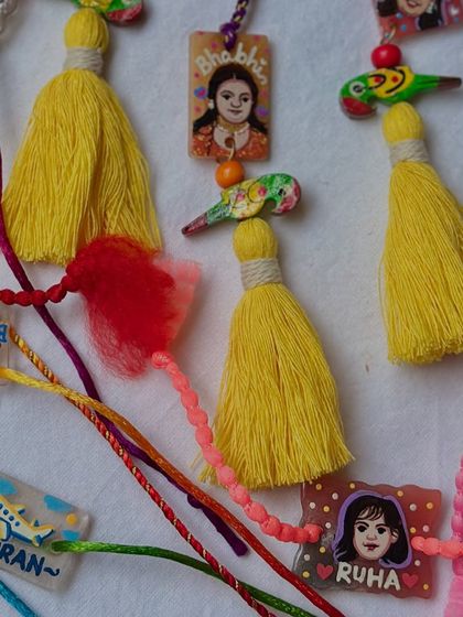 A beautiful assortment of our custom Rakhis, featuring names, portraits, and colorful tassels.