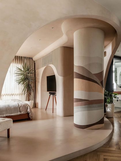 The master suite was designed as a single, fluid space. An obstacle, a lone column, was transformed into a statement piece with custom wallpaper, anchoring the room's design.