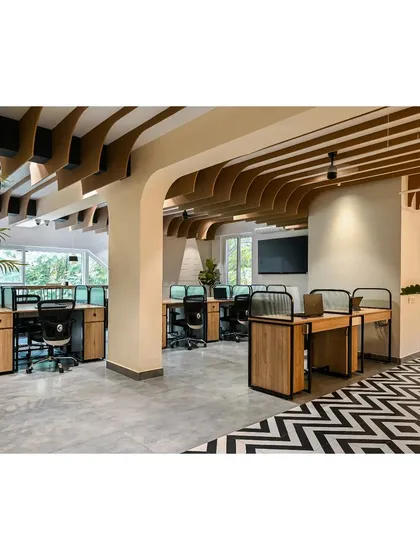 The workstations are positioned near large windows to take advantage of natural light and views of the surrounding trees. The warm oak desks and fluted glass partitions complement the overhead ceiling fins.