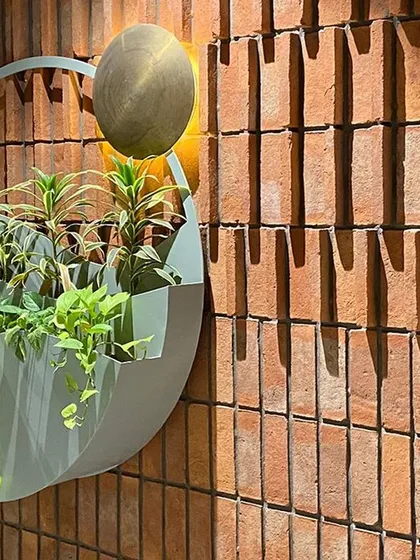 The play of light and shadow across the textured brick wall adds another layer of depth to this artful planter installation. It is a small moment of beauty that enriches the space.