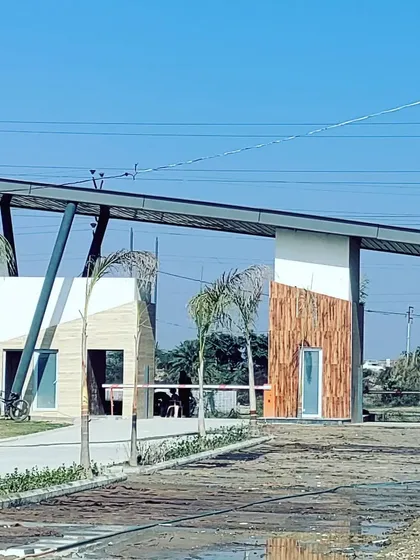 Another perspective of the main gate at the Kanpur row housing project. This view highlights the angular support structures and the mix of textured and smooth surfaces, showcasing the detailed thought put into every element of the community's design.