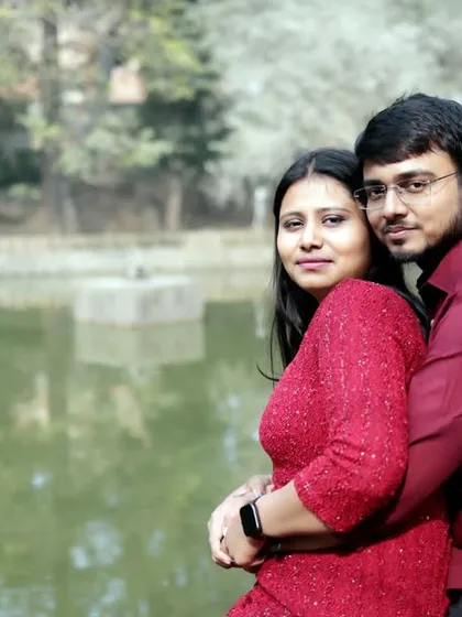 A warm and intimate portrait of the couple hugging by the lake. This close-up shot focuses on their happy expressions and the beautiful natural lighting of the park.