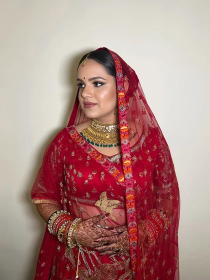 The bride with her dupatta, looking elegant and timeless. The makeup is perfectly balanced for a classic bridal look.