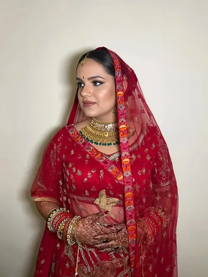 The bride with her dupatta, looking elegant and timeless. The makeup is perfectly balanced for a classic bridal look.