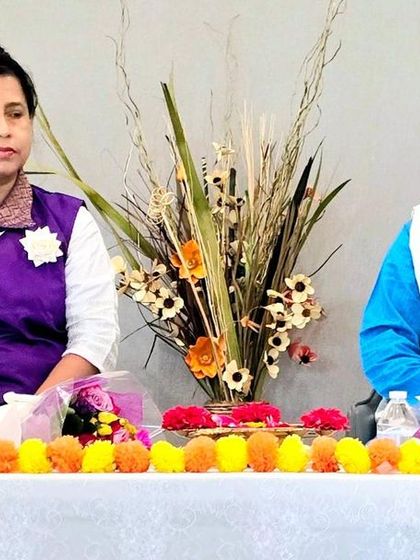 We are seated at a table adorned with flowers during our Satsang and Meditation program in the USA. This image conveys the calm and welcoming atmosphere of our events.