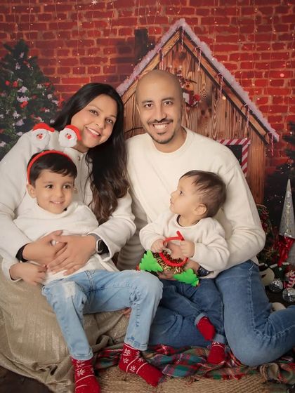 A happy family moment during our Christmas mini-sessions. The festive backdrop and coordinated outfits make for a perfect holiday portrait.